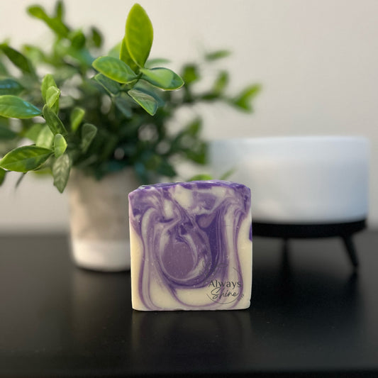 Picture displays a single bar of soap that has swirls of purple and white. 