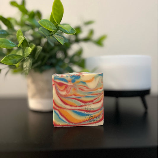Picture displays a single bar of soap that has swirls of red, orange, yellow, green and blue.