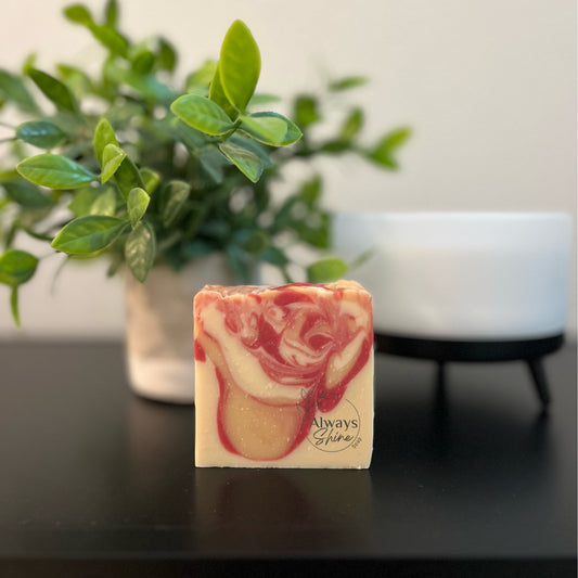 Picture displays a single bar of soap that has swirls of red, gold and white. 