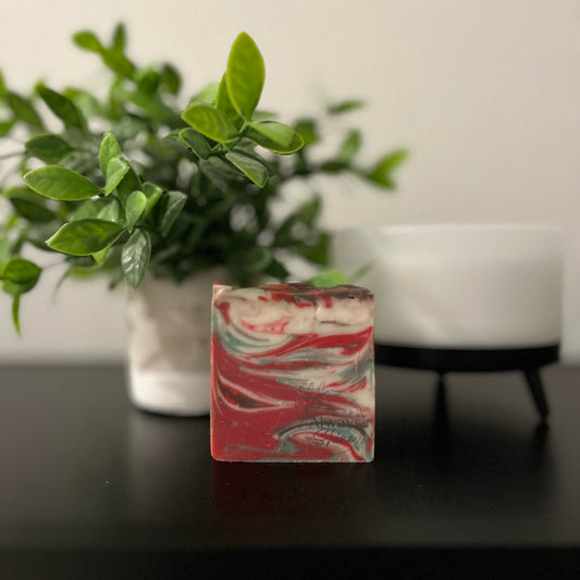 Picture displays a single bar of soap that has swirls of green, red and white. 